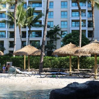 thatch umbrellas around a beach lounging area